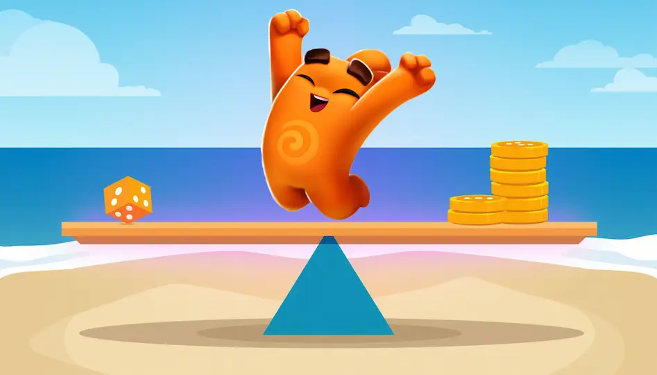 An orange die and a stack of gold coins are on opposite ends of a seesaw on a beach.